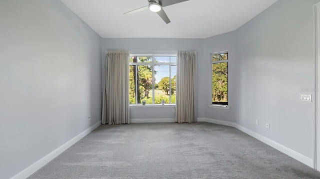 empty room featuring ceiling fan and light colored carpet