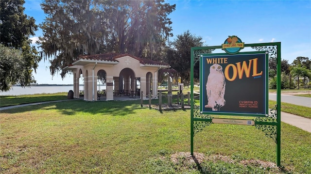 view of home's community with a water view and a lawn