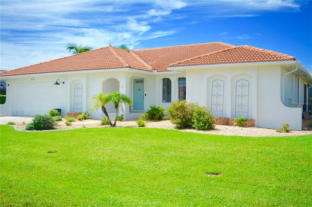 mediterranean / spanish house featuring a front yard and a garage