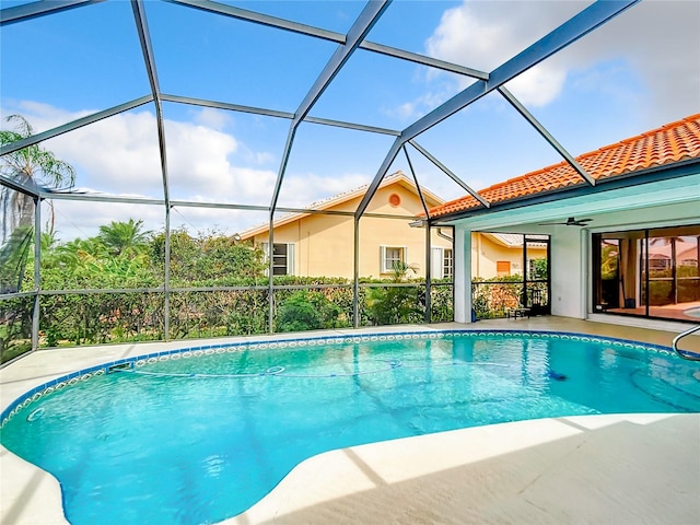 view of pool with glass enclosure and ceiling fan