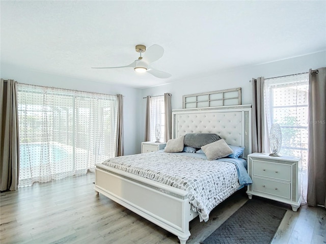 bedroom with ceiling fan, light wood-type flooring, and multiple windows