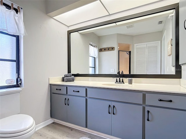 bathroom with hardwood / wood-style floors, vanity, and toilet