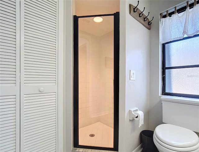 bathroom with toilet and a shower with shower door