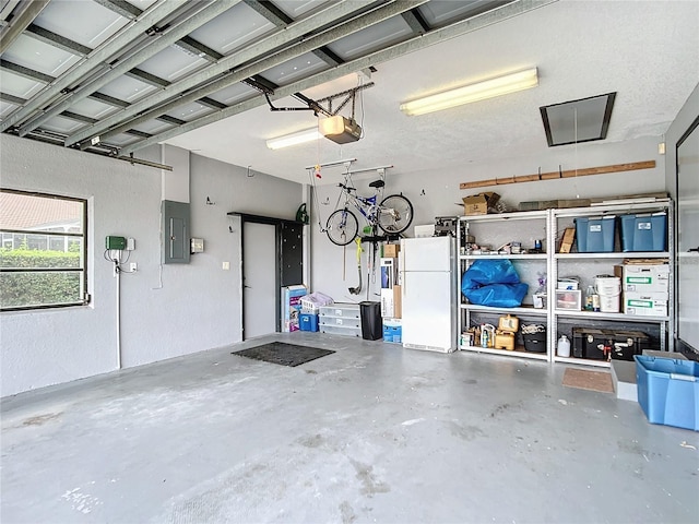 garage with electric panel, white fridge, and a garage door opener