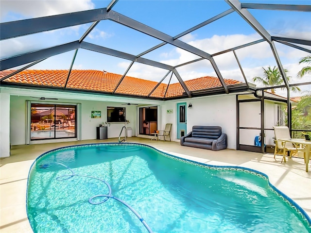 view of swimming pool with a patio, ceiling fan, and a lanai