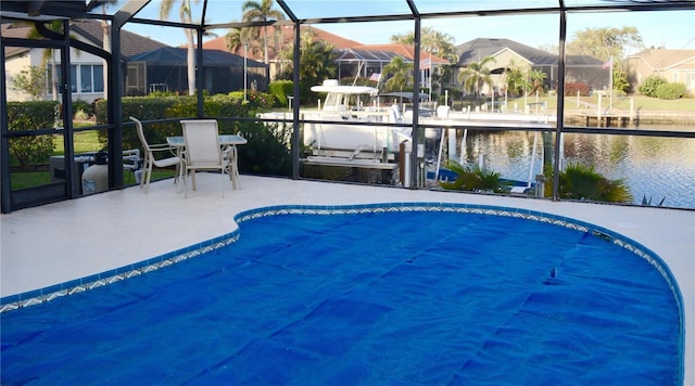 view of swimming pool featuring a water view, a lanai, and a patio area