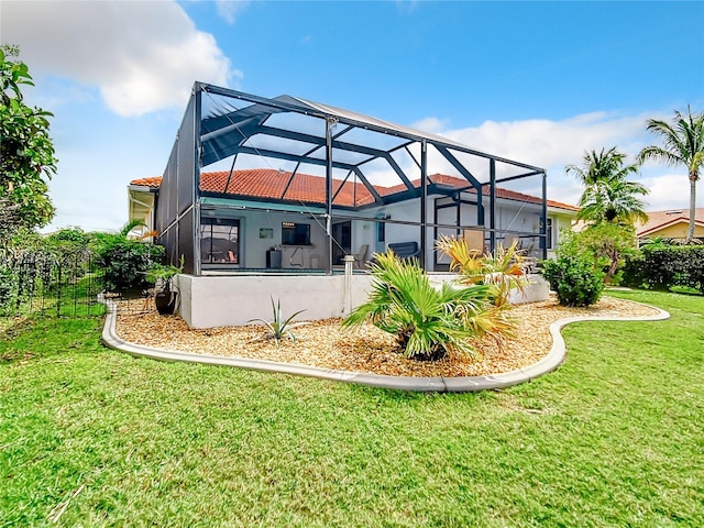 rear view of property with a lawn and a lanai