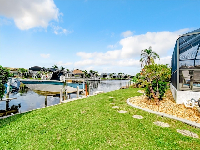 dock area featuring a lanai, a lawn, and a water view