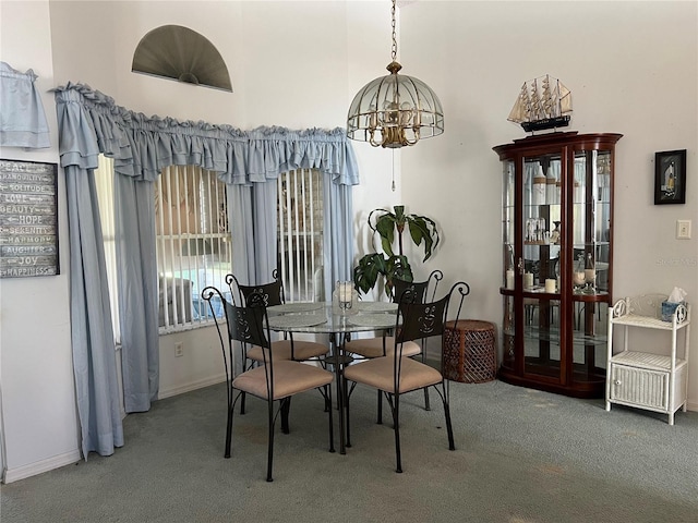 dining area with carpet flooring and a notable chandelier