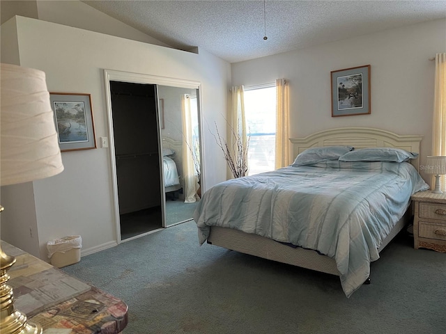 carpeted bedroom with a textured ceiling, vaulted ceiling, and a closet