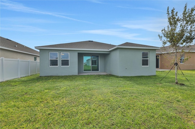 back of house featuring a patio and a yard