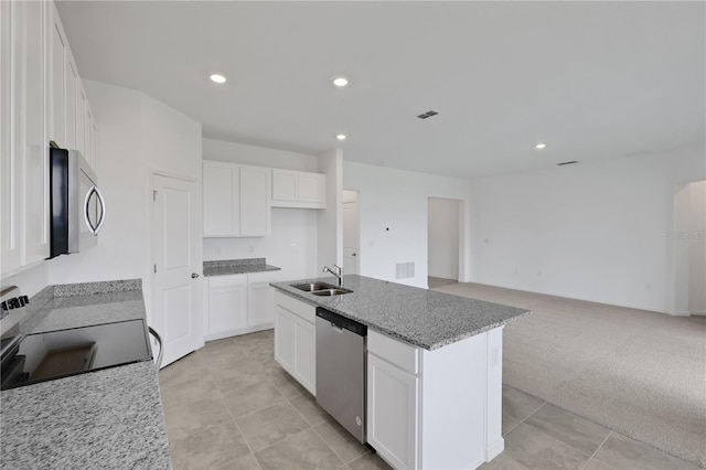 kitchen with a center island with sink, white cabinets, light carpet, sink, and appliances with stainless steel finishes