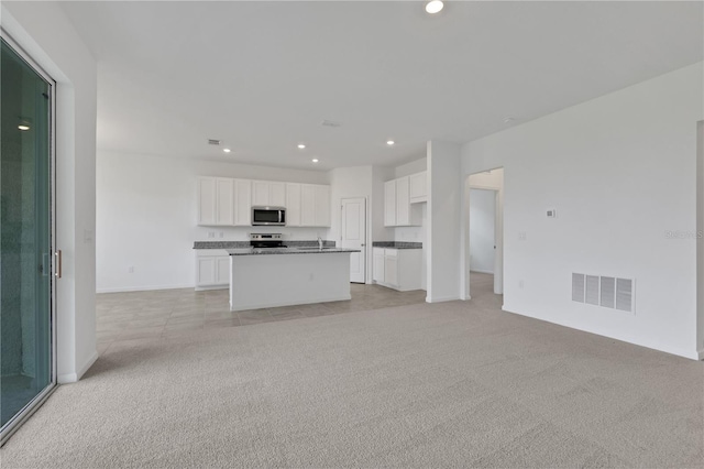 unfurnished living room featuring light colored carpet and sink