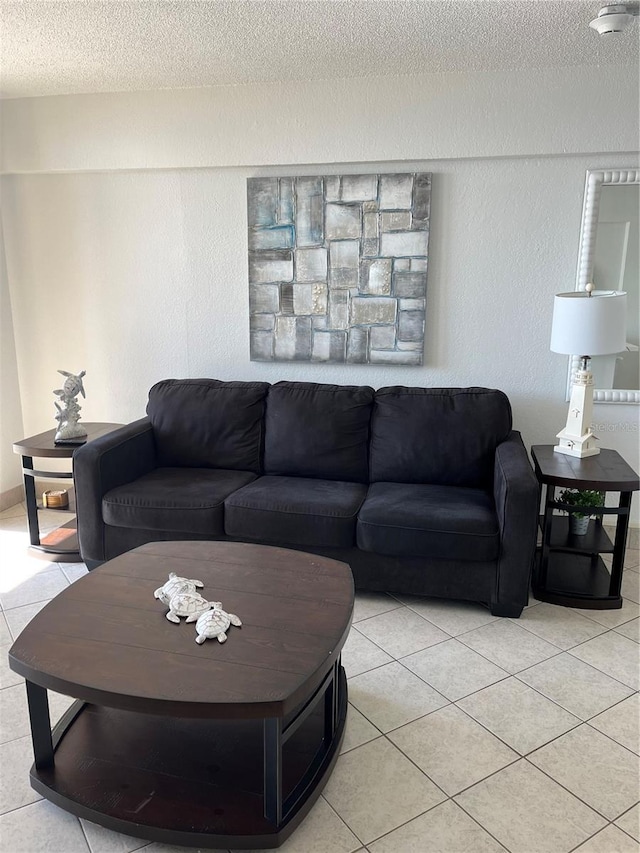 living area with a textured ceiling, light tile patterned floors, and a textured wall