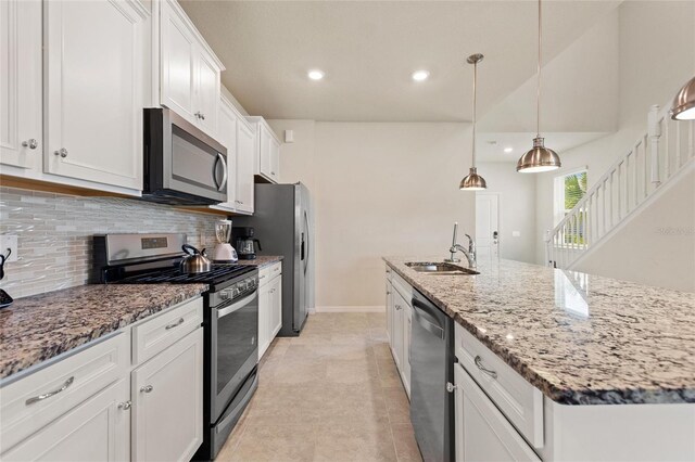 kitchen featuring decorative light fixtures, white cabinetry, sink, stainless steel appliances, and tasteful backsplash