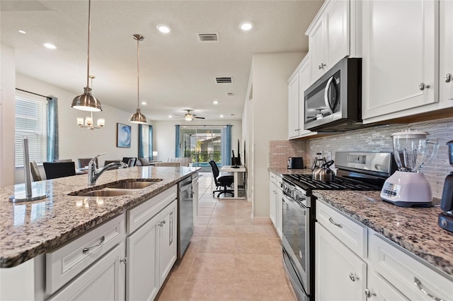 kitchen featuring pendant lighting, stainless steel appliances, ceiling fan, tasteful backsplash, and white cabinets