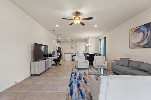 living room featuring ceiling fan with notable chandelier and light tile floors