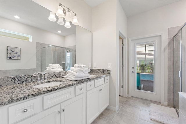 bathroom featuring an enclosed shower, a notable chandelier, tile floors, dual sinks, and large vanity