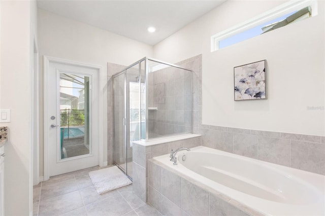 bathroom featuring a healthy amount of sunlight, tile flooring, and separate shower and tub