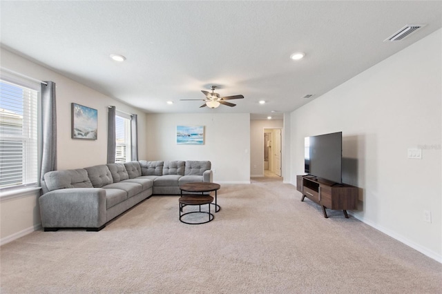 carpeted living room with ceiling fan and a wealth of natural light