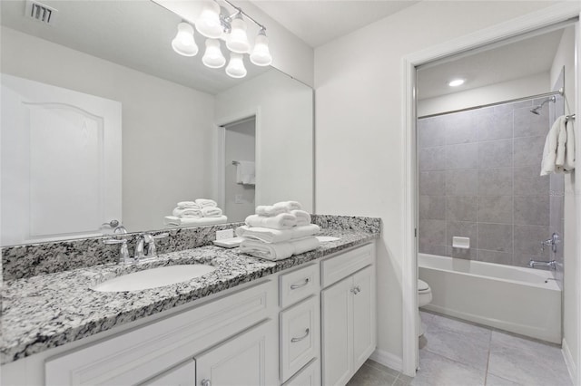 full bathroom with toilet, double vanity, tile floors, and tiled shower / bath combo