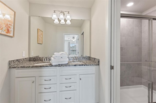 bathroom featuring an enclosed shower, double vanity, and ceiling fan with notable chandelier