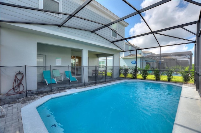 view of swimming pool with a patio area and a lanai