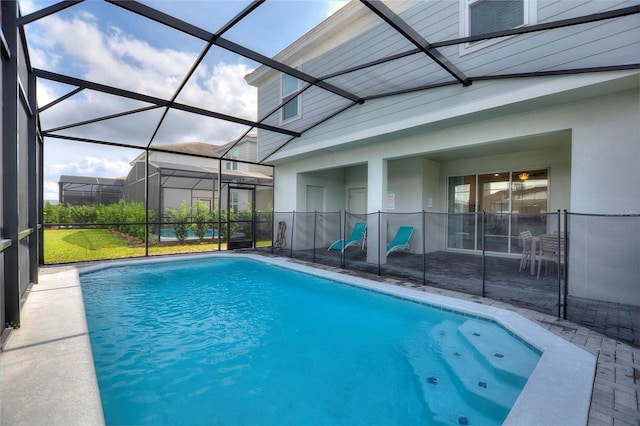 view of pool featuring glass enclosure and a patio