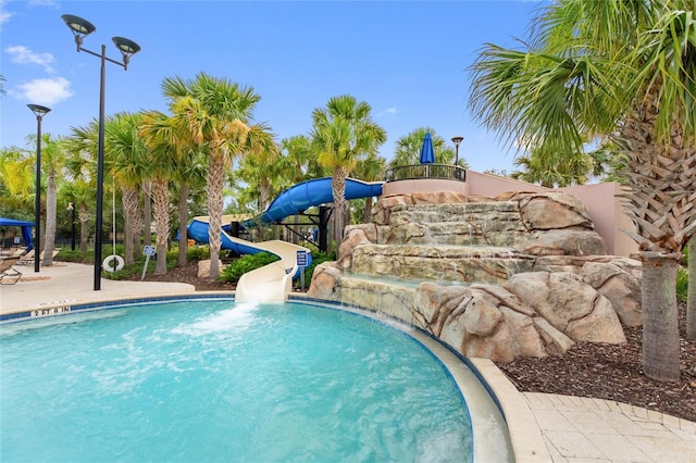 view of pool with a water slide and pool water feature