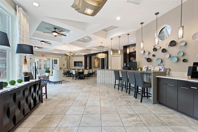 tiled dining area featuring coffered ceiling, beam ceiling, plenty of natural light, and ceiling fan