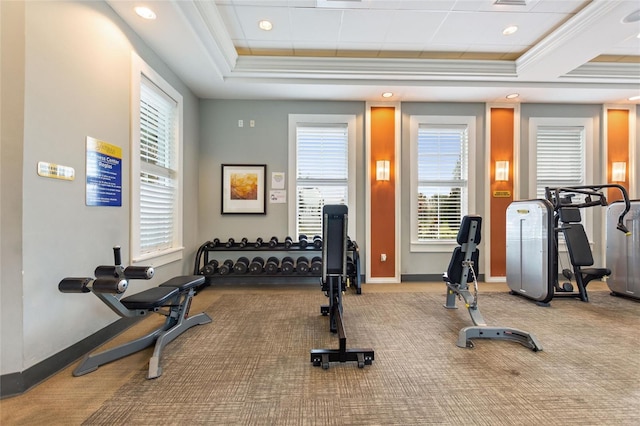 workout room featuring crown molding, a tray ceiling, and light carpet