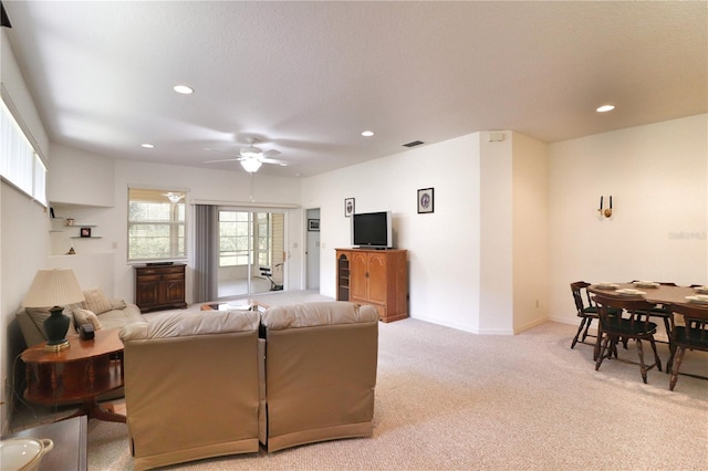 carpeted living room with ceiling fan