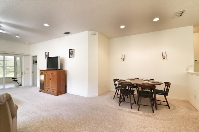 carpeted dining area featuring a textured ceiling