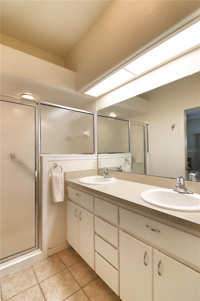 bathroom featuring double vanity, tile flooring, and walk in shower