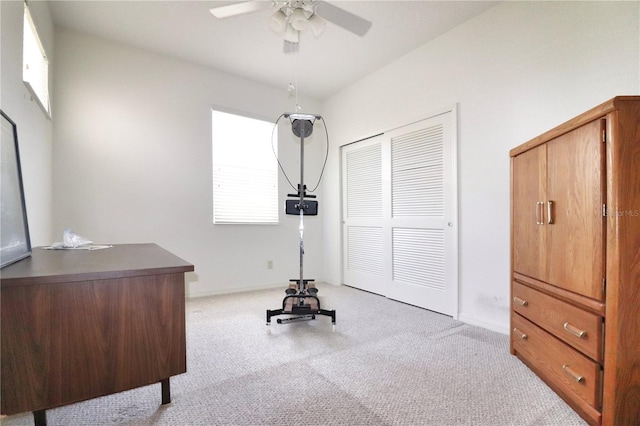 exercise area with a healthy amount of sunlight, light colored carpet, and ceiling fan