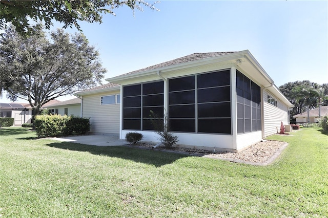 rear view of property featuring a yard and a sunroom