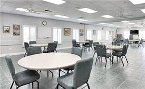 dining space with light tile flooring and a drop ceiling