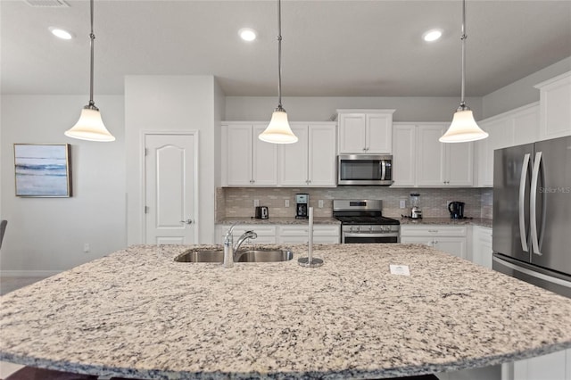 kitchen with pendant lighting, white cabinets, and appliances with stainless steel finishes