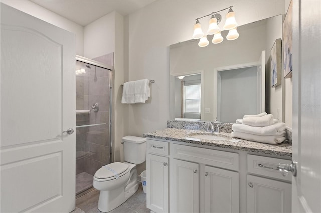 bathroom with toilet, large vanity, a shower with shower door, and tile flooring