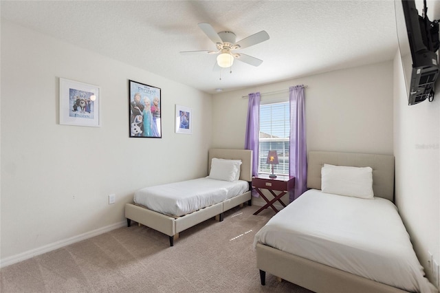 bedroom featuring carpet flooring, a textured ceiling, and ceiling fan