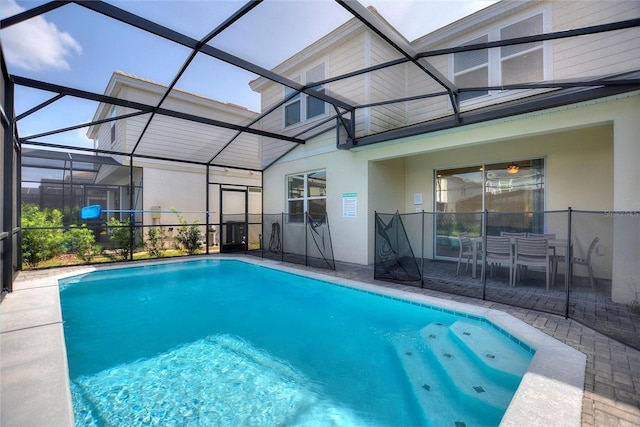 view of swimming pool featuring a patio area and glass enclosure