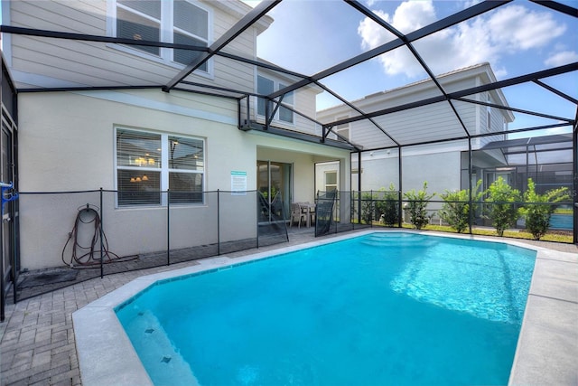 view of swimming pool featuring a patio area and a lanai