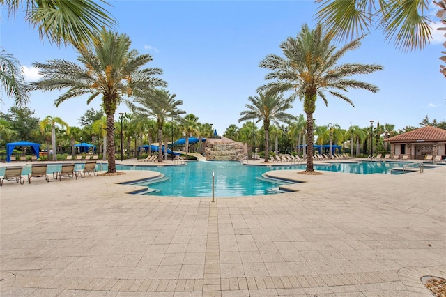 view of swimming pool with a water slide and a patio