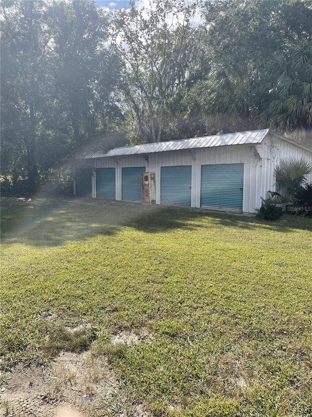 ranch-style house featuring a front yard, a garage, and an outbuilding