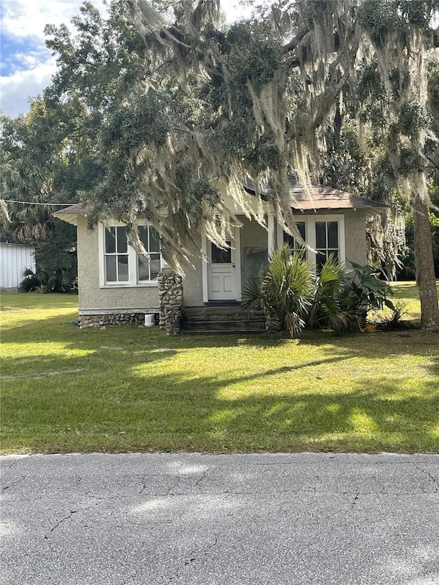 obstructed view of property featuring a front lawn