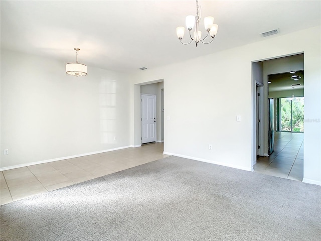 carpeted spare room featuring a chandelier