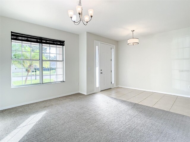 entrance foyer with a notable chandelier and light colored carpet