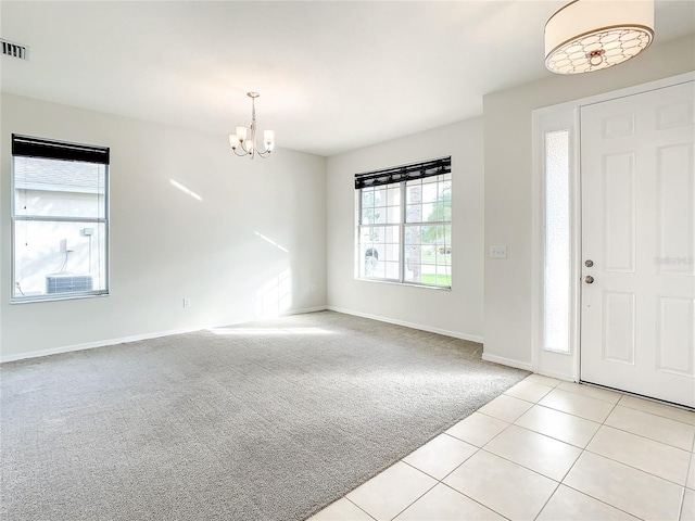 entrance foyer with a chandelier and light colored carpet