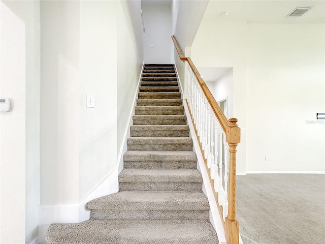 staircase featuring carpet