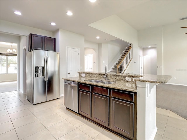 kitchen with dark brown cabinets, sink, an island with sink, and appliances with stainless steel finishes